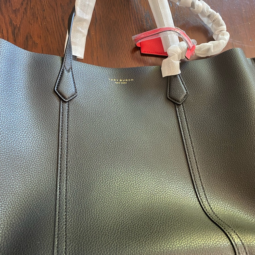 Black Tory Burch  tote . Red tassel accent. Large Zip middle pocket.
